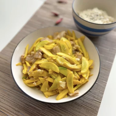 yellow courgette and pork belly stir fry served