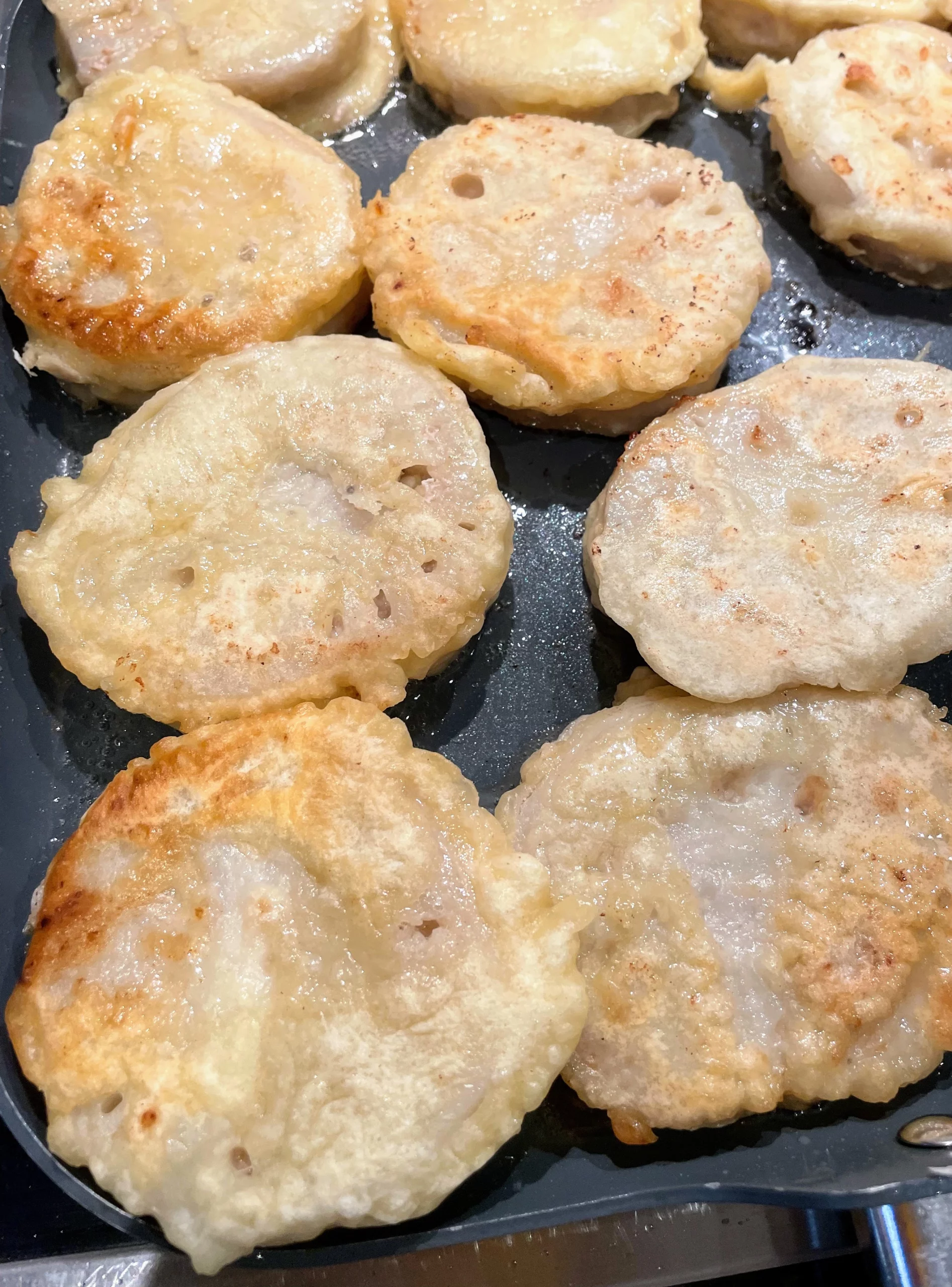 Golden brown lotus root and pork patties in pan