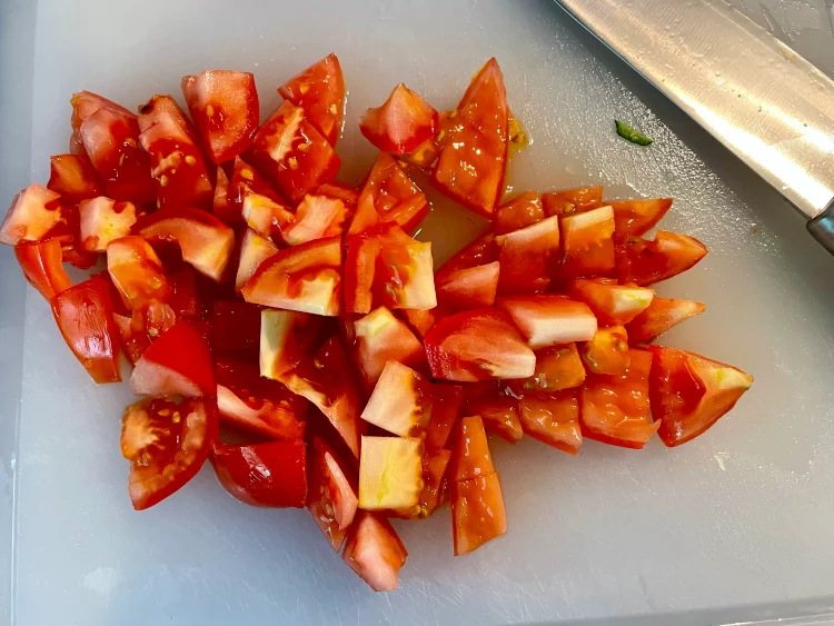 Fresh tomatoes chopped into small bite-sized pieces in a bowl.