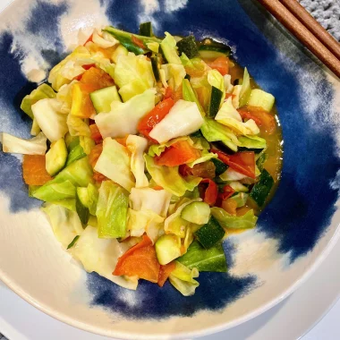 Sweetheart cabbage, courgette (zucchini), and tomato stir-fry served on a plate, ready to eat.