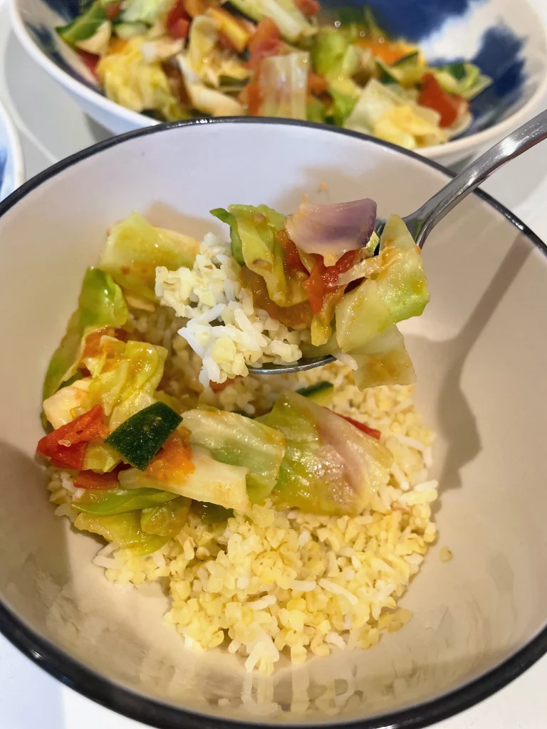 Colorful stir-fried vegetables plated and garnished, served with grains and ready for a healthy meal.