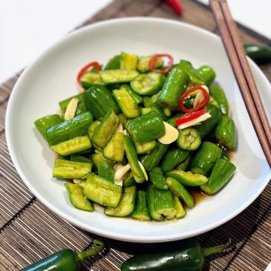 Chinese cucumber salad served in a bowl with garlic and chili garnish, showcasing a crunchy and refreshing appetizer.