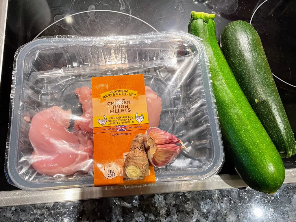 Ingredients for chicken courgette stir fry, including zucchini, chicken thighs, garlic, ginger, soy sauce, and sesame oil.