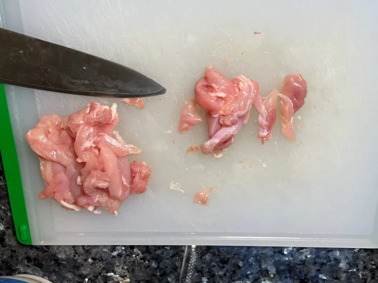 Chicken thigh fillets sliced into thin strips, ready to be marinated for stir fry.