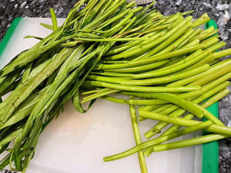 Freshly washed and chopped water spinach, divided into stems and leaves