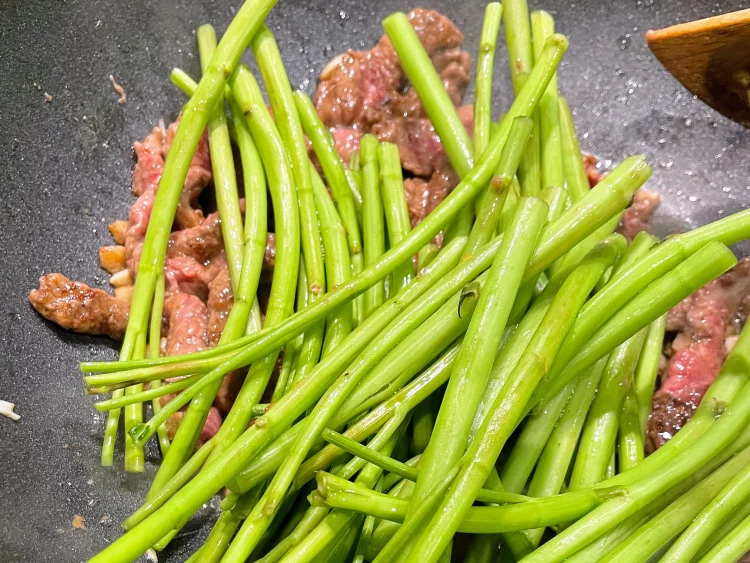 Adding water spinach stems to the Shacha beef stir-fry for extra crunch